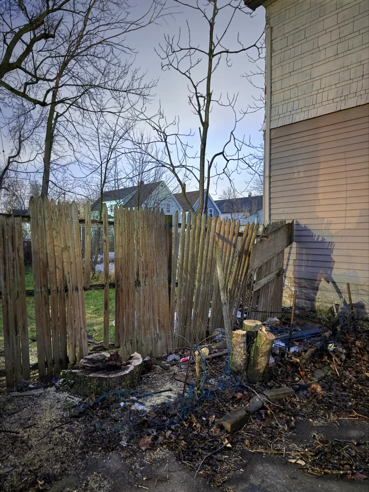 Decayed tree trunk and damaged fence showing advanced trunk decay after hazardous tree failure risk in Buffalo NY